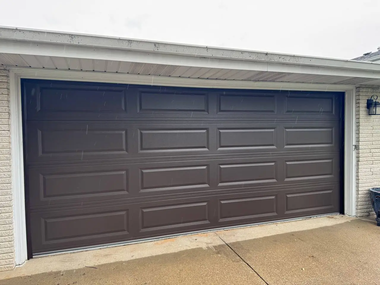 New brown raised-panel double garage door